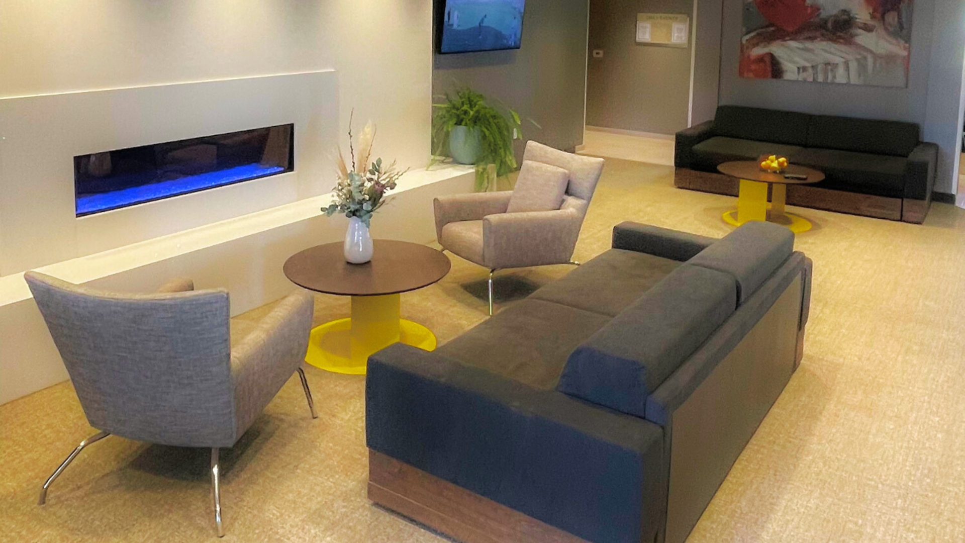 Lobby area with a fireplace and gray couches.