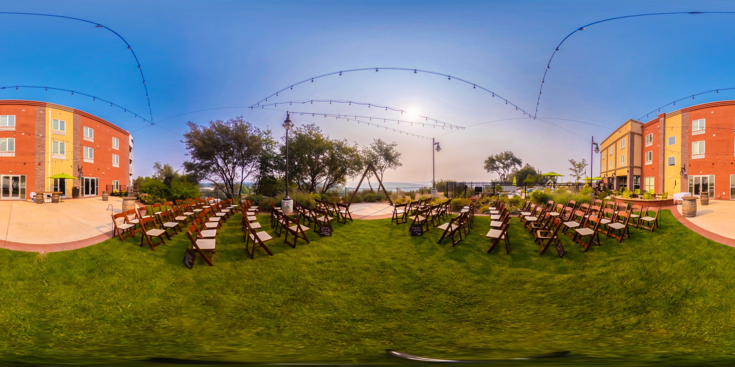 Chairs are lined outside on a green grass.
